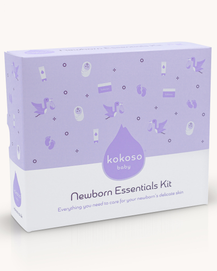 The Kokoso Newborn Essentials Organic Baby Gift Set in its purple and white box, stood upright on a cream background