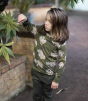 Meyadey Roaming Rhino organic long sleeved top in deep mossy green with detailed rhino and savannah plants print. For by child with long hair, looking at the plants to the side