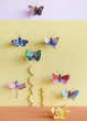Collection of Studio Roof butterfly and insect decorations on a pastel yellow  coloured wall with a pastel lilac border on the top 