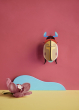 Studio Roof Lemon Fruit Beetle decoration hung up on a pinkish red painted wall