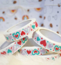 A stack of Babipur Love Heart Paper Tape, a white self-adhesive paper tape with a gorgeous love heart and stars print in red, turquoise and purple.