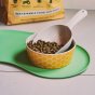 Beco Pets pet food bowl on top of green placemat on a white kitchen floor.