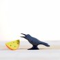 Close up of the Bumbu handmade raven and cheese toy set on a white wooden background with the cheese next to the raven