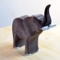 Close up of the Bumbu hand carved large wooden elephant kids toy stood on a light wooden work top