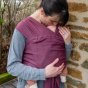Close up of woman kissing baby in the close caboo cotton blend baby carrier in the burgundy colour