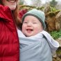 Close up of a baby laughing in the close caboo lite baby carrier in the alloy colour