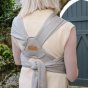 Close up of woman wearing the close caboo organic porpoise baby carrier showing the straps across her back