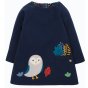 Frugi long sleeve reversible peek-a-boo dress in indigo with owl & leaf appliques on the dress' bottom right, a pocket on the left with leaf applique and embroidery on white background