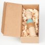The Grapat Stacking Figure Wooden Stacker Toy, stacked in a human figure form. Made from natural wood and a pastel blue painted section, simply packaged in a cardboard box with wood shavings. White background. 