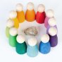Grapat 12 Nins Wooden Peg Dolls in a circle, lined up in the colours of the rainbow around a white crystal. A classic Waldorf peg doll toy for open ended play. White background.