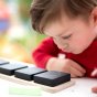 Close up of child looking at the Hellion Toys eco-friendly wooden chalking cubes on a white table