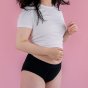 Hey Girls Basic Brief - Black Period Pants worn by a person wearing a white top against a pink background