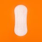 Hey Girls Natural Bamboo & Corn Fibre Disposable Panty Liner open on an orange background