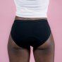 Hey Girls Essential Bikini - black Period Pants worn by a person wearing a white top against a pink background