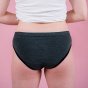Hey Girls Essential Bikini - Grey Period Pants worn by a person wearing a white top against a pink background
