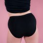 Hey Girls Mid Waist Black Reusable Period Pants worn by a person with a black top against a pink background