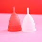 Hey Girls white Small Silicone Menstrual Cup and large red silicone Menstrual Cup on a pink and red background