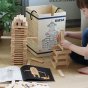 Young child stacking the Kapla eco-friendly wooden shapes into a tower on a wooden floor