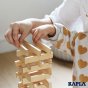 Close up of a child's hands stacking up the Kapla natural wood building blocks into a lattice structure