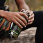 Close up of a man holding the Klean Kanteen reusable stainless steel camo tkwide drinks bottle
