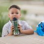 Boy sat at a park table drinking from the Klean Kanteen eco-friendly tkwide insulated metal water bottle