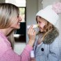 Woman rubbing the Kokoso Organic lavender baby balm stick on a young girls nose