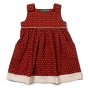 Little Green Radicals organic cotton childrens burnt ochre polka dot pinnie dress laid out on a white background
