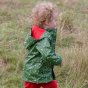 Boy running through a grass field wearing the little green radicals rocket to the stars waterproof jacket 