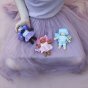 Olli Ella Holdie Folk Fairies - Bluebell, Tulip and Willow on the lap and hand of a child wearing a purple tulle tutu