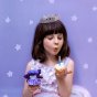 Olli Ella Holdie Birthday Fairy Doll - Bluebell - held by a child blowing out a birthday cucake