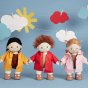 3 Olli Ella dinkum dolls stood on a blue background wearing the ahoy toy dress up raincoats in red, yellow and pink
