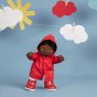 Olli ella dinkum doll stood on a blue background wearing the dress up rainy day outfit in red