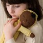 Close up of a girl cuddling an Olli Ella plush cotton Dozy Dinkum toy in front of a cream background
