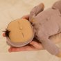 Close up of a soft Dozy Dinkum baby doll toy sleeping on a childs hands