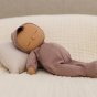 Close up of a plush cotton Olli Ella Dozy Dinkum doll sleeping on a cream bed