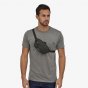 This is a picture of male model wearing the Patagonia hip pack in black across chest. Model is standing in front of white background.(Hip pack is in black for style reference only this colour is not sold on website).