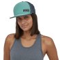 Woman stood on a white background wearing the Patagonia eco-friendly teal blue duckbill trucker cap 