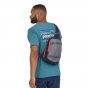 Man stood backwards wearing the Patagonia eco-friendly atom sling cross body bag in navy on a white background