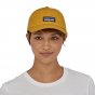 Picture of model wearing the gold trad cap (front view). Picture background is white.