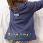 back of a girl wearing  long sleeve blue tunic with colourful star embroidery along the hem from piccalilly