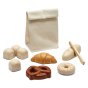 Plan Toys childrens wooden bread toy set laid out on a white background next to its soft fabric storage bag