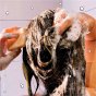 Woman applying a Shower Blocks natural 2 in 1 shower and conditioner bar to her hair in the shower
