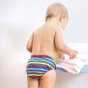 Close up of toddler stood wearing the Totsbots eco-friendly swim stripe reusable swim pants on a white background