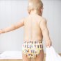 Close up of toddler stood up in the Totsbots surfs up eco-friendly reusable baby swim pants 
