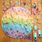 Toys by Nature wooden pastel rainbow play board covered in multicoloured Grapat Mandala pieces on a wooden floor