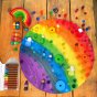 Toys by Nature wooden rainbow play board covered in multicoloured Grapat Mandala pieces on a wooden floor