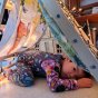 Young boy laying under a wooden Triclimb climbing frame with the Wonder Cloths large world map cloth draped over the top