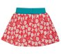 back of vibrant pink organic cotton jersey skirt with a beautiful white seashell print, layered over shorts with a stretchy fold-down blue waistband from frugi
