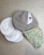 Close maternity breast feeding pads on a grey floor next to the Close pastel print pad pouch