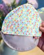 Close up of a hand holding the Close Parent eco-friendly pastel print breast pad pouch